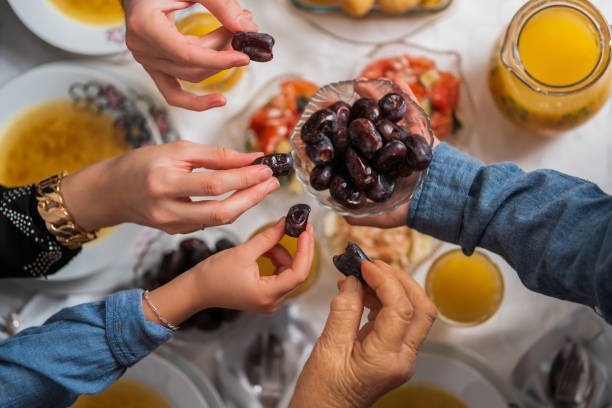 Happy Muslim family having iftar dinner to break fasting during Ramadan dining table at home or restaurant. . High quality photo